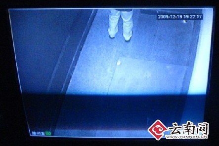 实验的记者跟门还有一段距离，但是通过监视镜头已无法看见其上半身